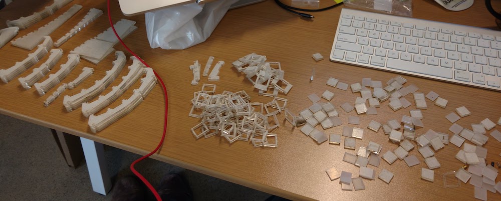 A pile of small pieces of acrylic I had just picked up from the laser cutting service strewn about the surface of my desk